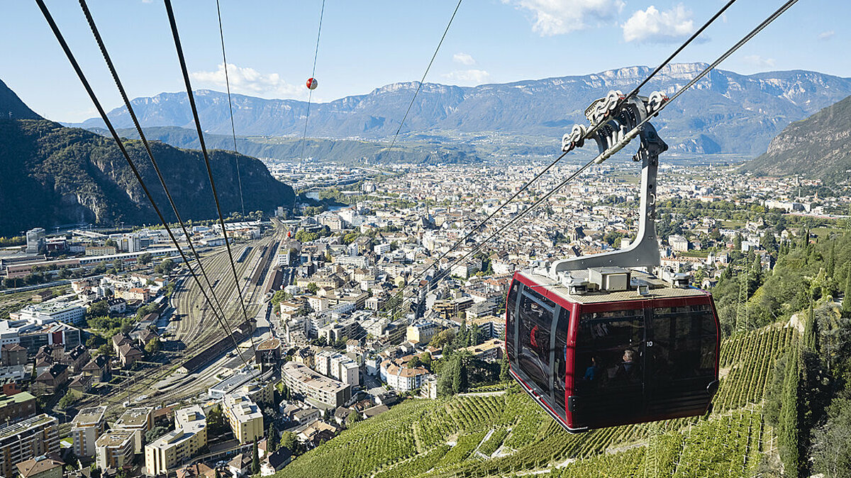 Cabina della funivia del Renon in discesa, con vista panoramica su Bolzano.