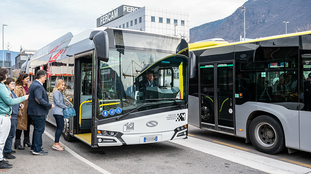 Passeggeri salgono su un bus urbano elettrico in città.