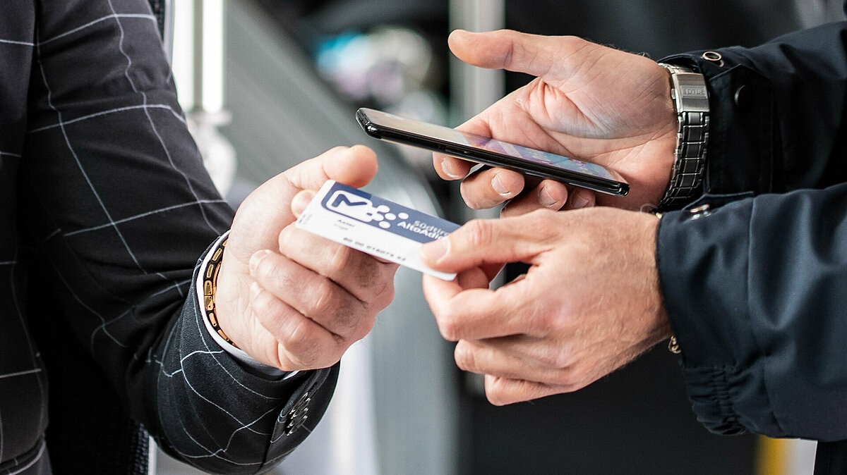 Particolare delle mani del controllore che controlla un biglietto.